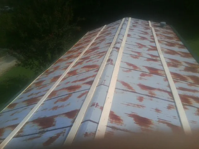Rusted metal roof panels with new wood purlins before replacement — Storm Damage Roof Repair in Martin by Roofing Brothers